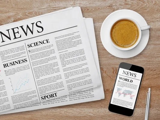 Newspapers, a phone and a cup of coffee for the weekly market review
